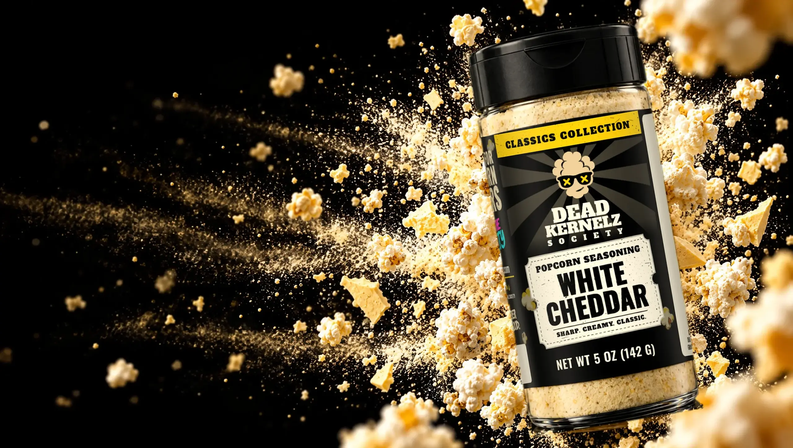 Dead Kernelz White Cheddar popcorn seasoning bottle in a blast of popcorn and white cheddar